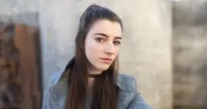 young woman with long straight brown hair thinking