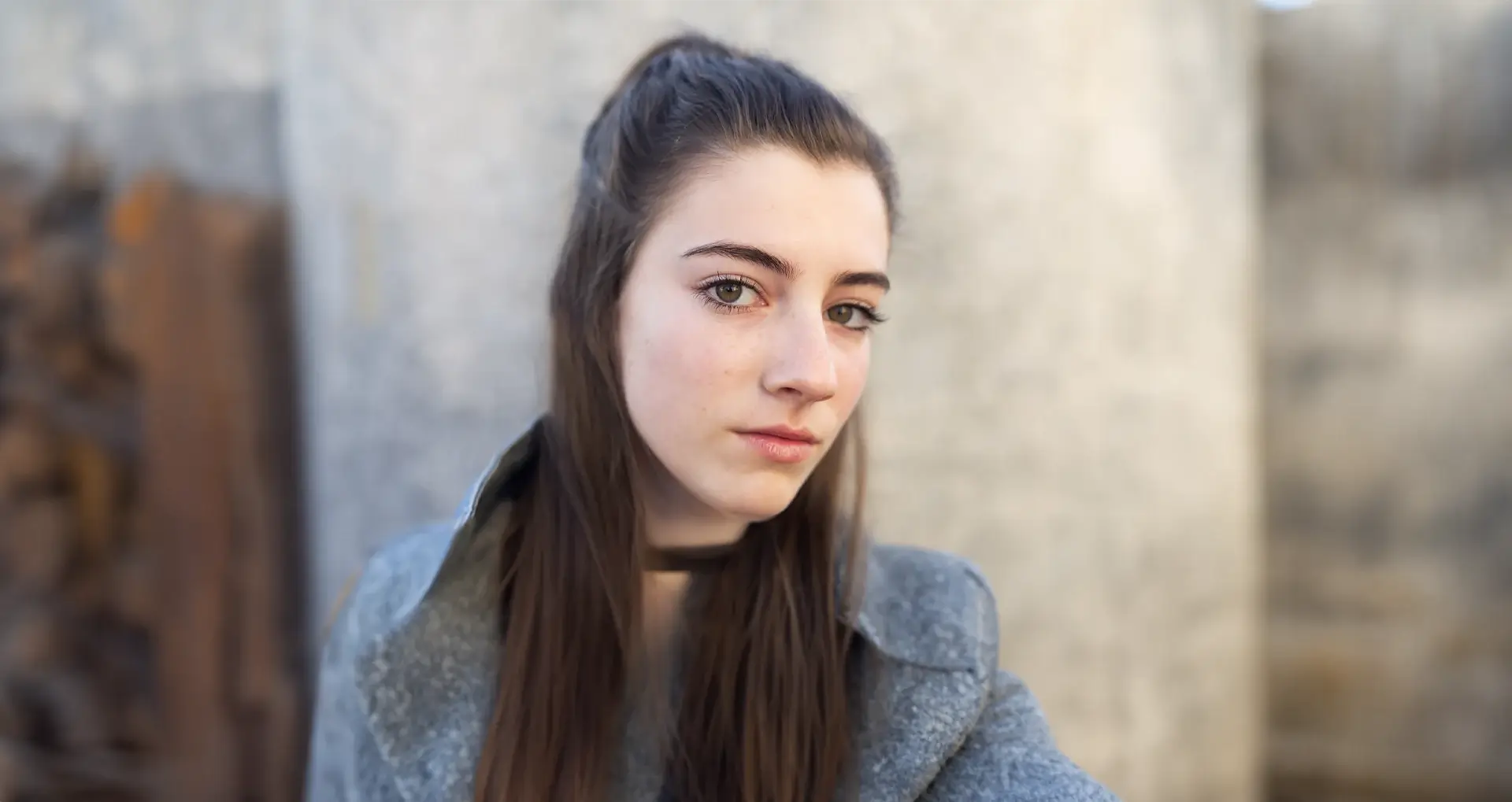 young woman with long straight brown hair thinking